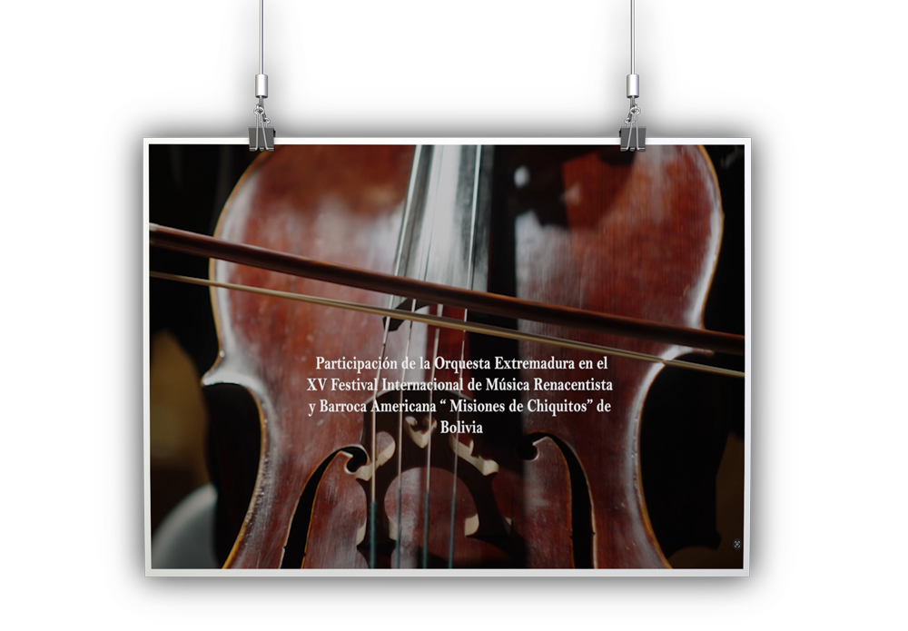Close-up of a violin with a white-bordered photo hanging, displaying a Spanish caption about the Orquesta Extremeña’s participation in Bolivia’s XV Festival Internacional de Música Renacentista y Barroca Americana.