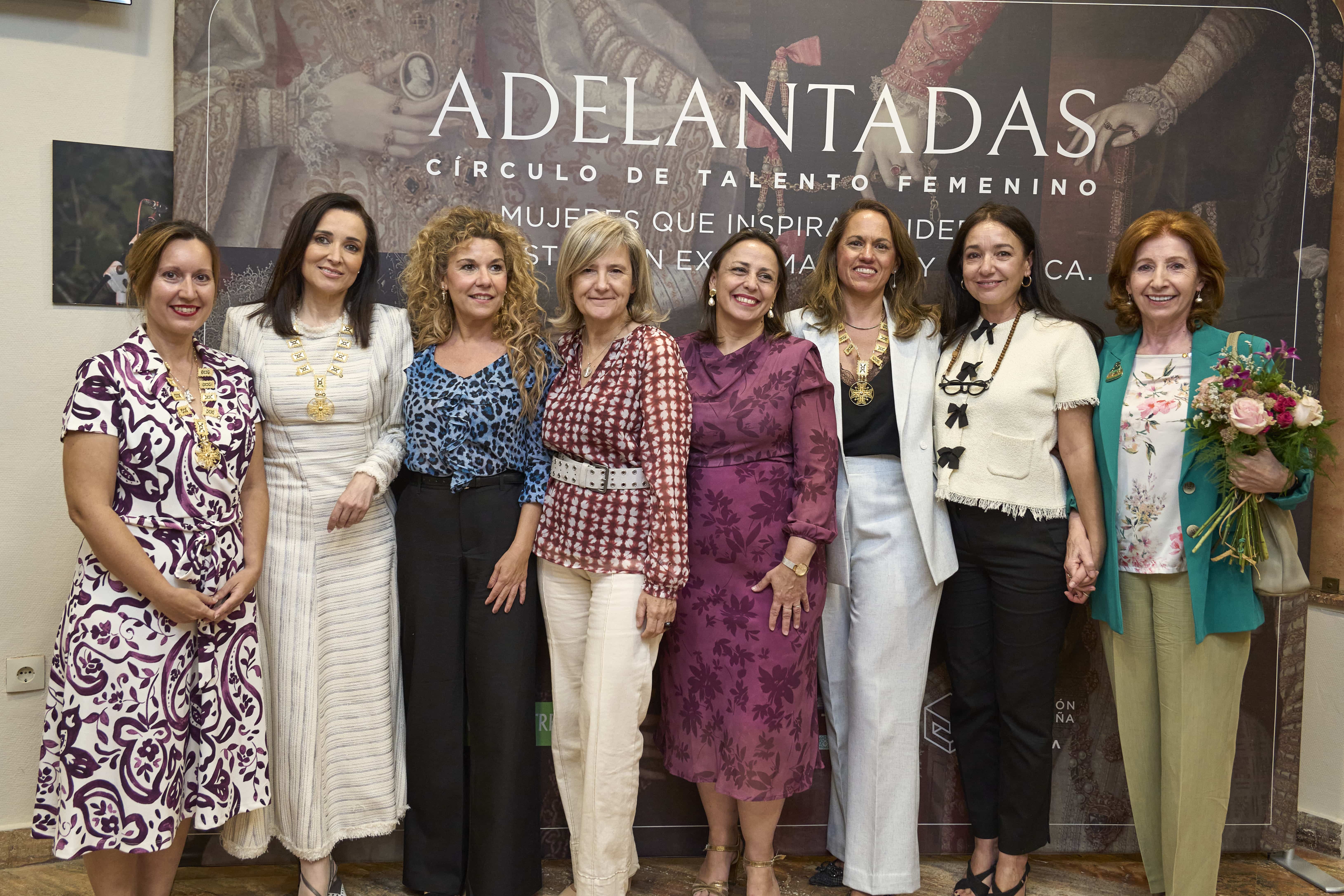 Group of eight women in colorful professional outfits posing together in front of a large banner that reads ADE LANTADAS/CÍRCULO DE TALENTO FEMENINO, smiling for the camera.
